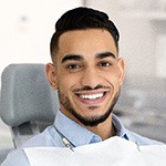 Patient smiling while sitting in treatment chair