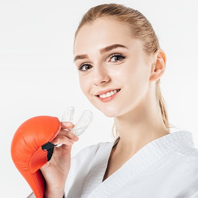 Teen girl with boxing gloves placing athletic mouthguard