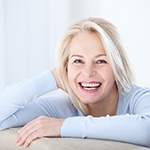 Senior woman leaning on couch and smiling