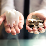 coins and tooth representing cost of dentures in Frisco