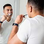 Man brushing his teeth to prevent a dental emergency in Frisco 