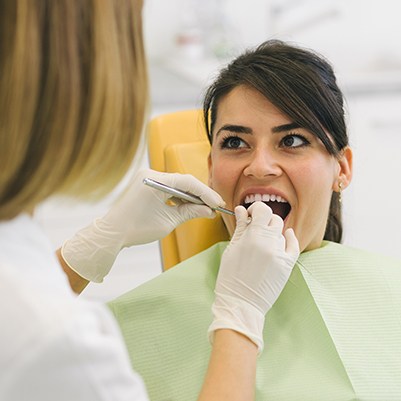 Dental team member examine patient's smile
