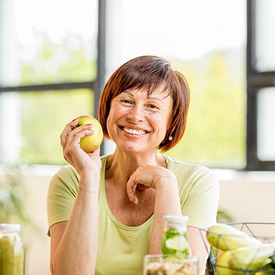 smiling woman holding an apple 