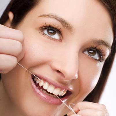 Woman smiling while flossing teeth