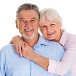 Older couple smiling with arms around each other