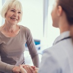 Older patient speaking with an implant dentist in Frisco