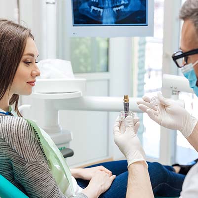 dentist showing a dental implant to a patient