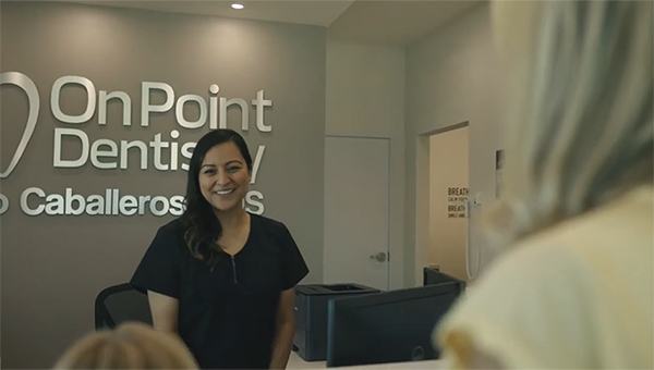 Dental team member in Frisco greeting patients at front desk