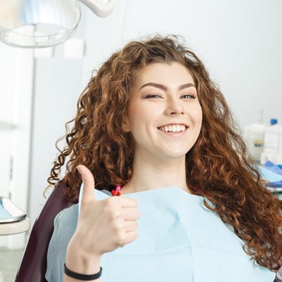 smiling woman giving a thumbs up at her sedation dentist in Frisco 