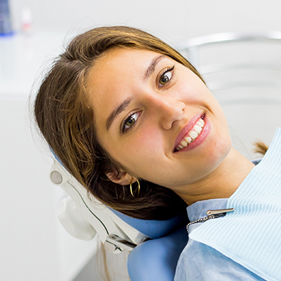 Smiling woman at dental office for antibiotic therapy