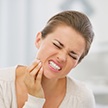 Woman in need of emergency dentistry holding jaw