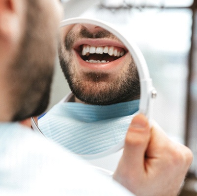 Patient smiling in dental mirror