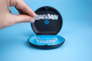 Patient lifting an Invisalign tray out of the case