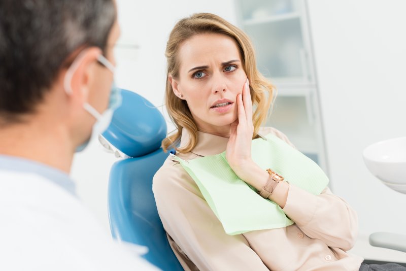 woman dealing with oral pain listening to dentist